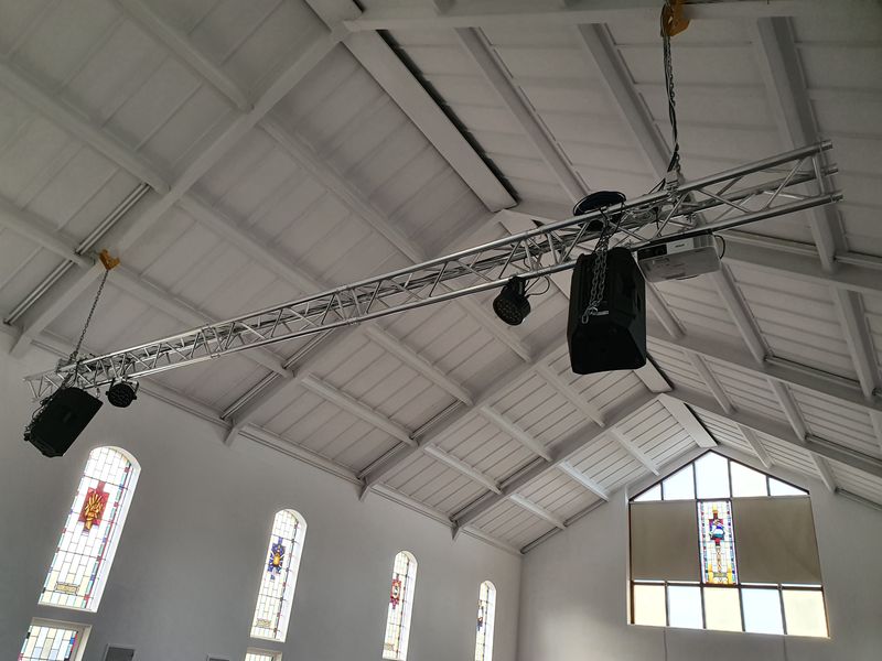 Lighting and speaker truss flown across a church ceiling